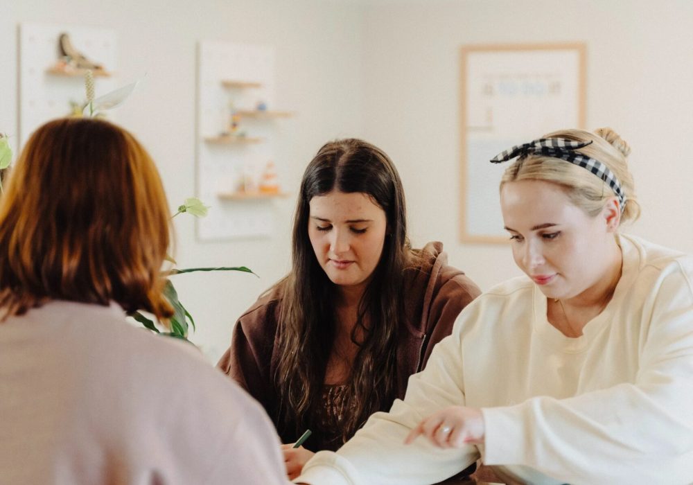 Three girls meeting at Startup Dunedin and discussing their ideas.